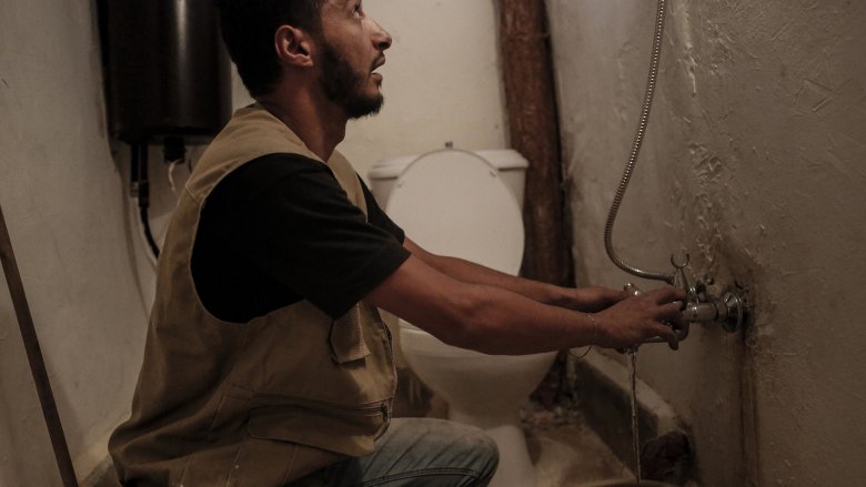 Water engineer Ahmed Al-Masry, 27, tests a shower and taps he recently installed in a house in Bab al Tabbaneh, Tripoli, Lebanon